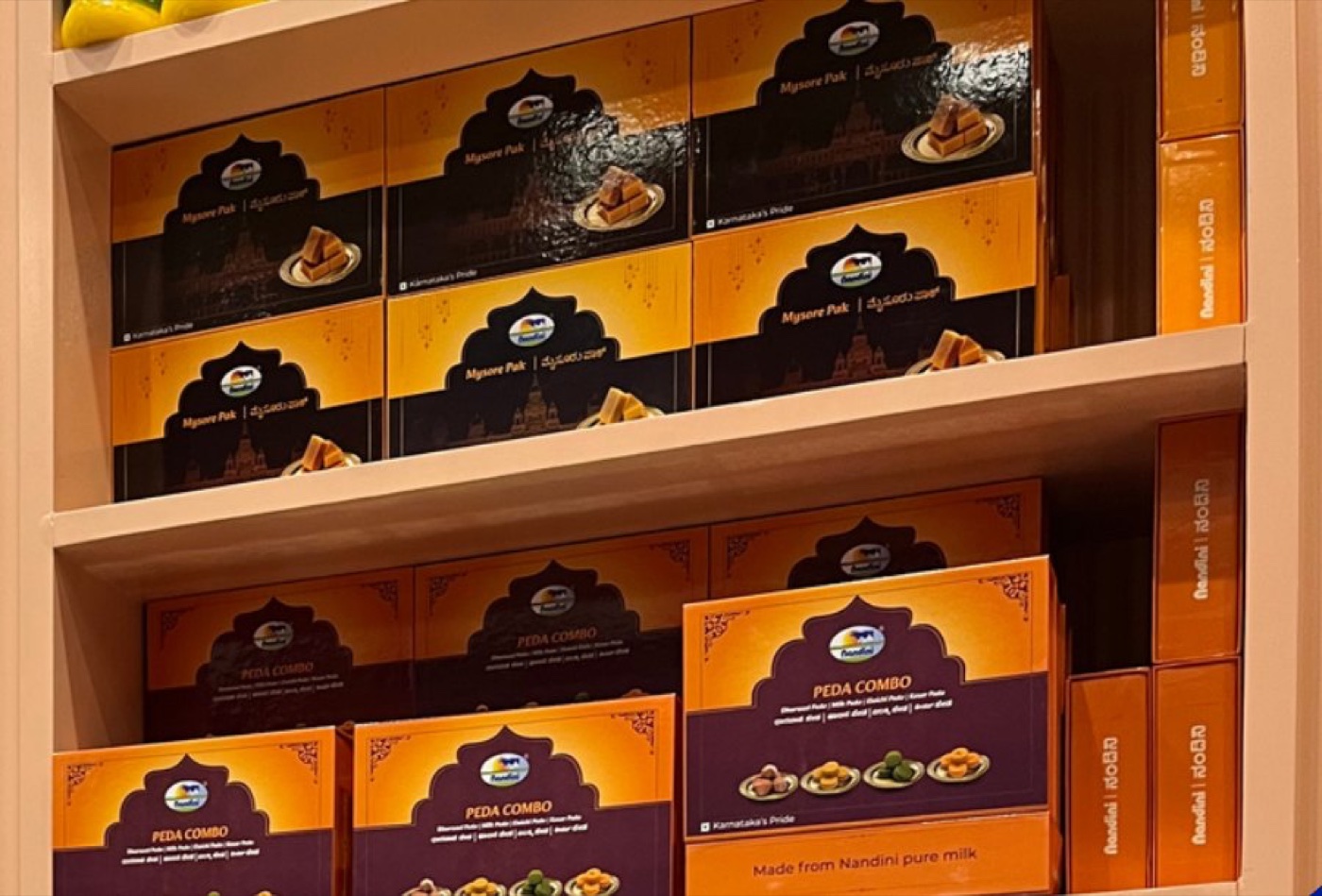 Nandini sweet boxes stacked on a shelf at Bengaluru airport